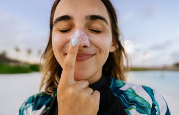 Woman applying sunscreen on her nose