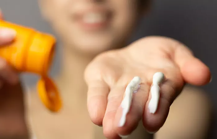 Woman showing the coorect amount of sunscreen to apply