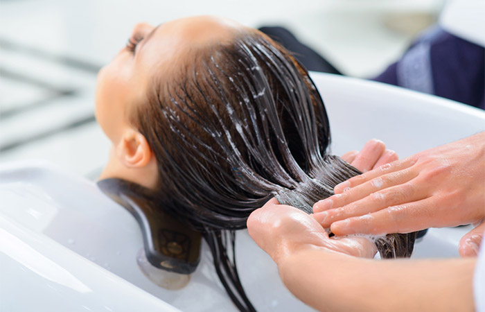 Woman undergoes olaplex hair treatment at salon.