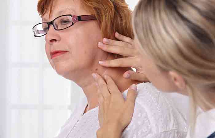 Doctor examines a skin tag on woman's neck