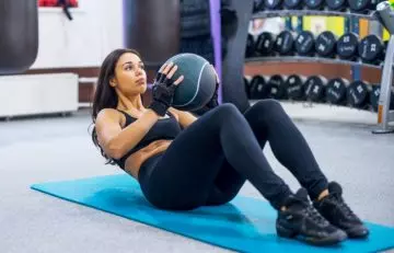 Woman doing weighted crunch exercise