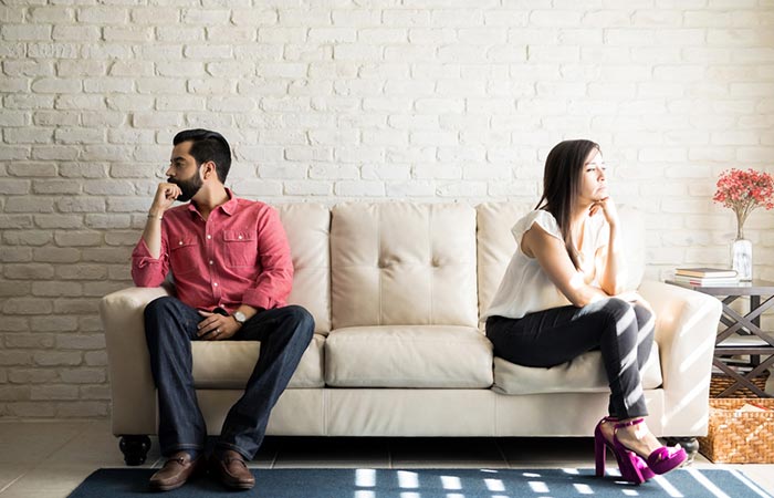  Young couple sitting on the couch and not talking after an argument at home.