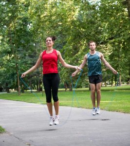 Man and woman jumping rope outdoors as a body composition exercise