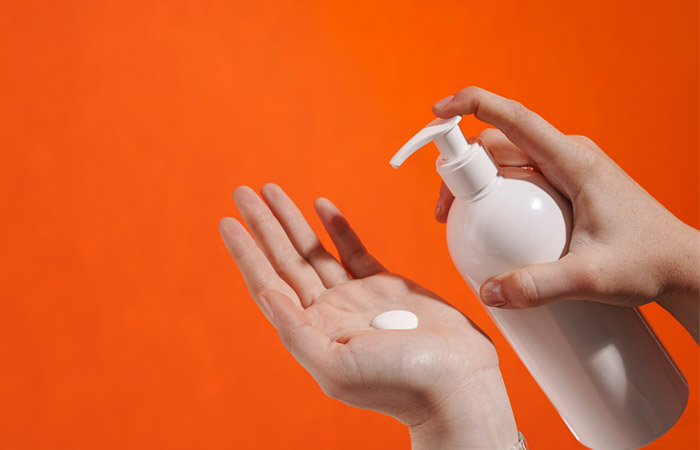 Close up of a hand pumping lotion.