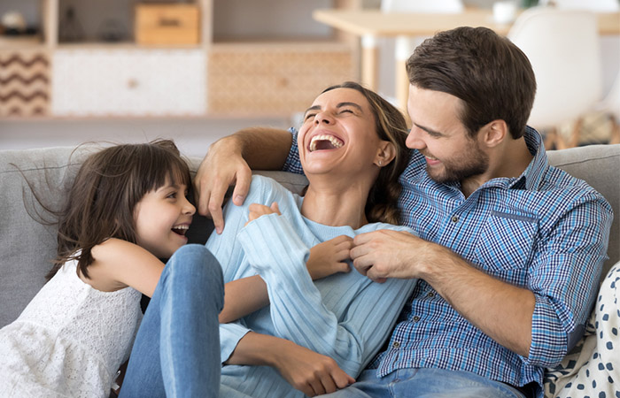 A cheerful family sitting on a couch