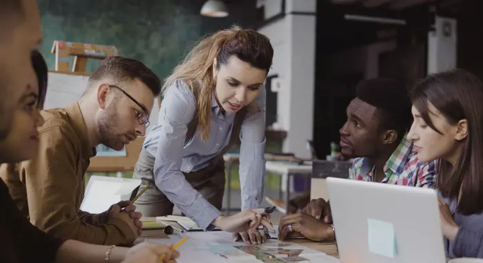 A confident Leo woman leading a team at work