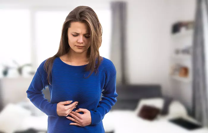 Woman feeling bloated due to sugar snap peas consumption