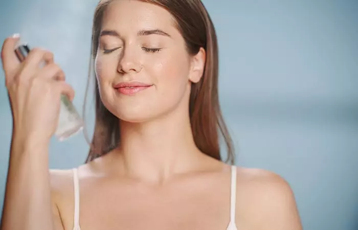 Woman using setting spray without makeup to hydrate her skin