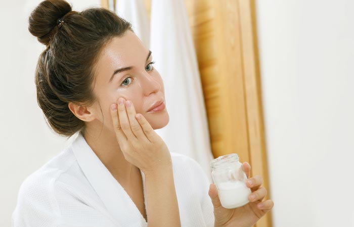 Woman using coconut oil as face moisturizer
