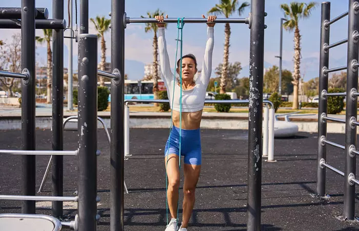 Woman performing banded pull-up exercise
