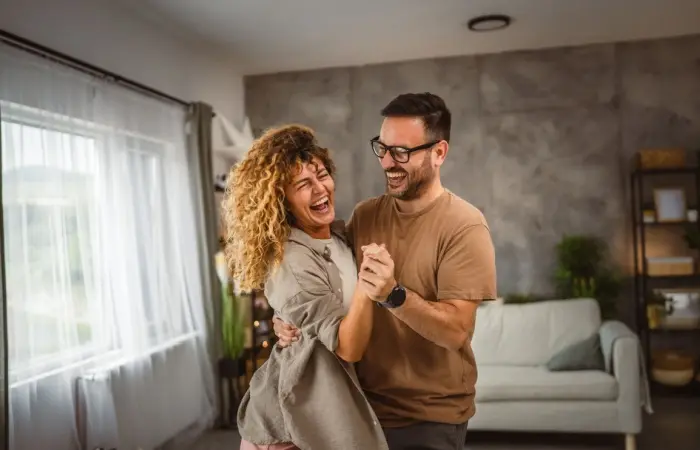 A couple dancing happily in their room