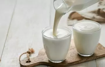 Kefir from a bottle being poured into two glasses
