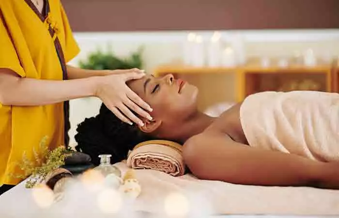 A woman getting a relaxing face massage with oil