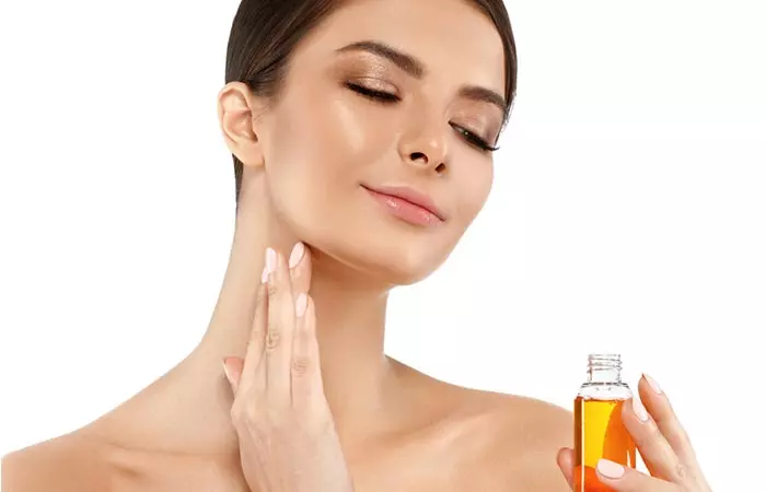 Woman applying soybean oil to her face