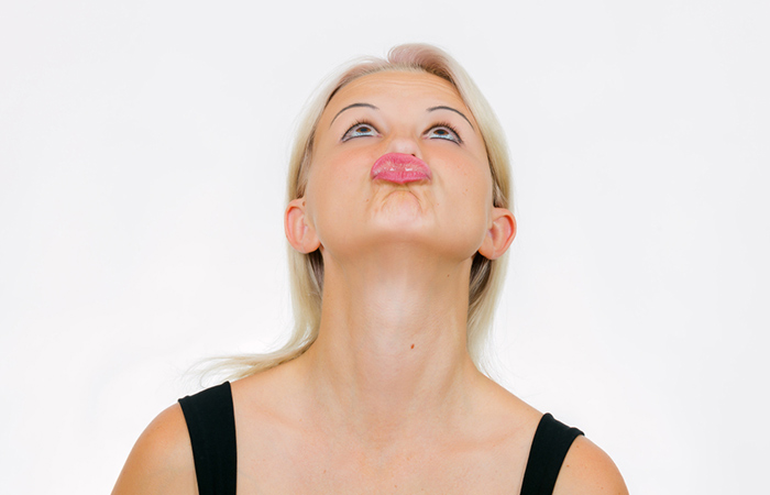 Woman demonstrates the chin lift exercise to reduce double chin for a slim face