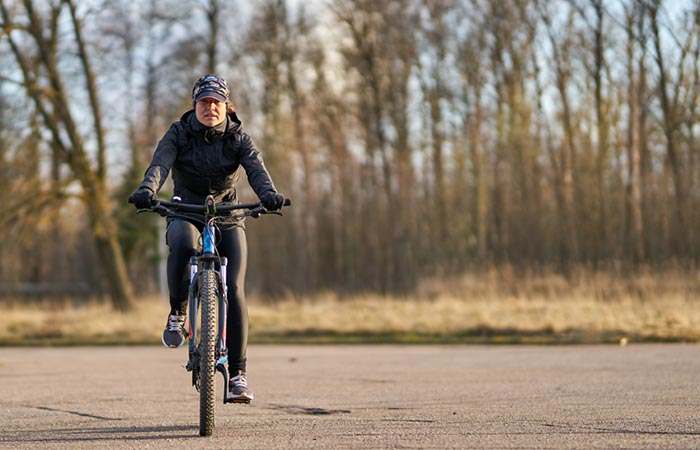 Mulher andando de bicicleta ao ar livre