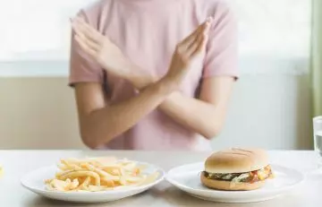 Woman rejecting high-calorie food