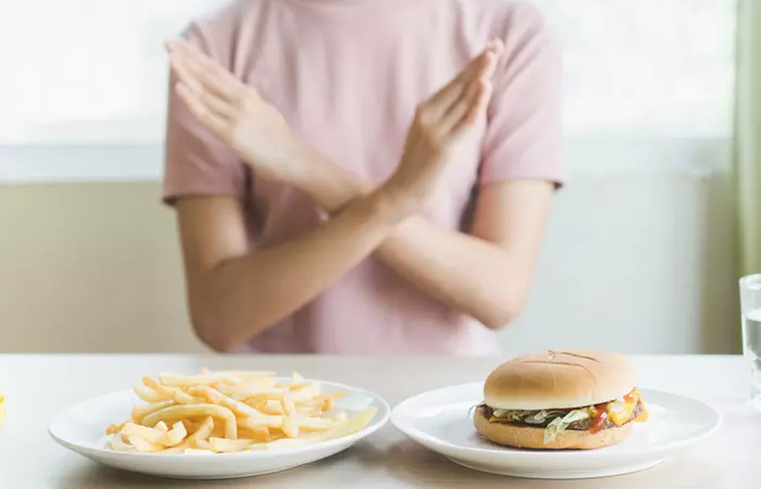 Woman rejecting high-calorie food