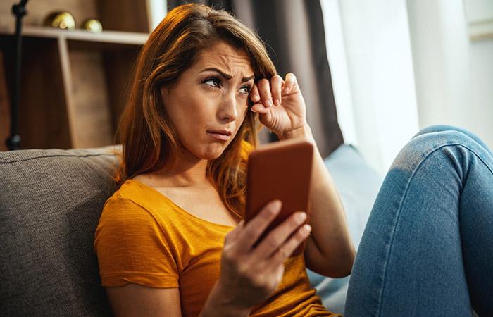 Sad woman sending condolence messages to a friend