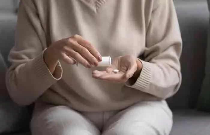 Woman taking valerian root tablet 