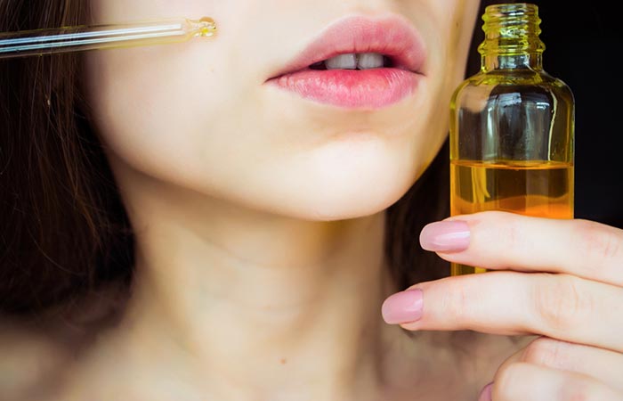 Woman applies soybean oil to her face using a dropper
