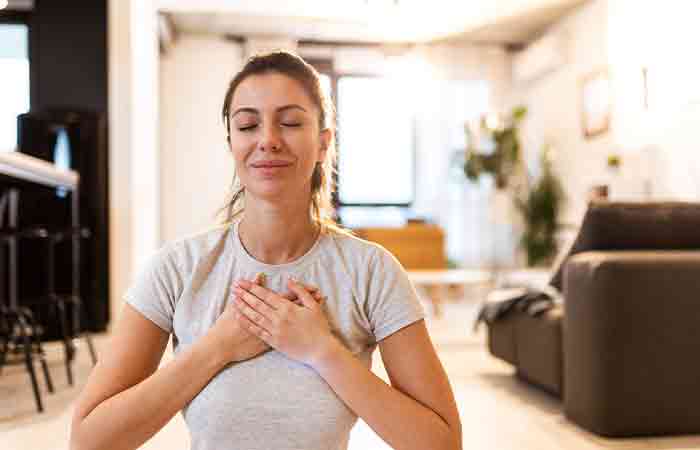 Woman with hands over her heart indicating good heart health