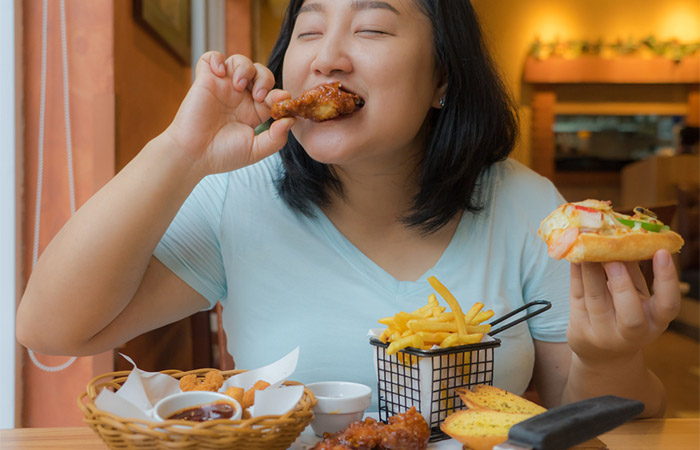A woman eating high-calorie junk food 