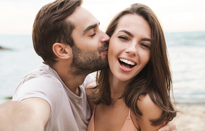 Man kissing a smiling woman