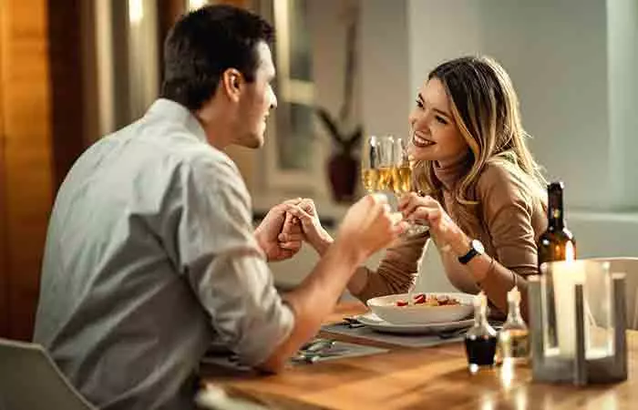 Couple holding hands over cups of coffee