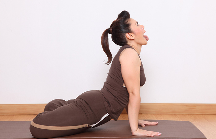Side view of girl pushing her tongue down towards her chin as part of the lion pose to slim the face