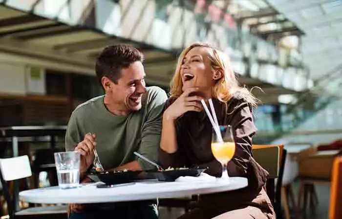 Couple laughing together and drinking wine