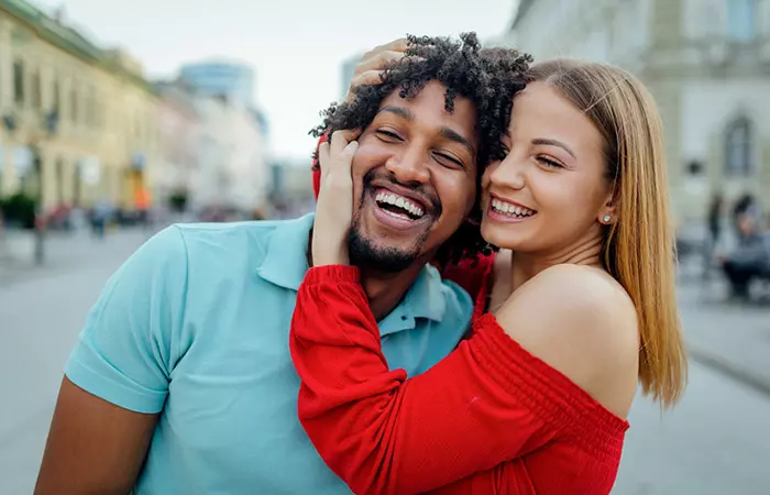 Woman playfully holding the head of a laughing Pisces man