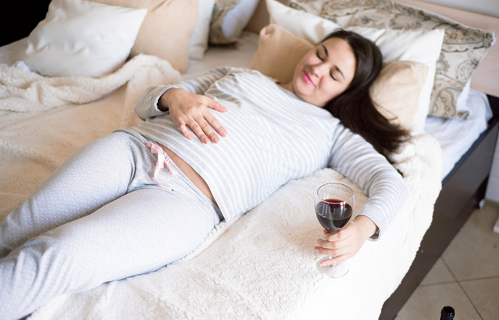 Woman checking her protruding wine belly