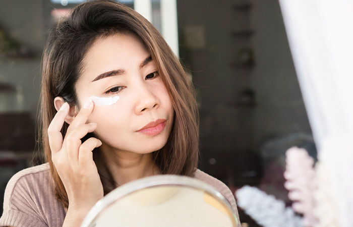 Woman applying retinaldehyde as an under-eye cream 