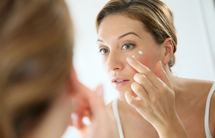 Woman using retinaldehyde cream to reduce wrinkles