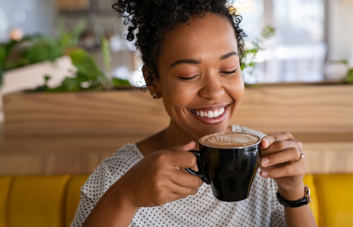 Woman freshening up her senses by drinking coffee