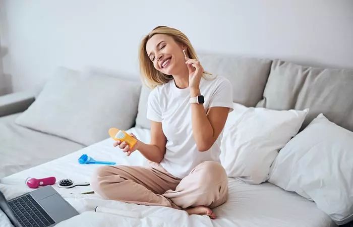 Woman scratching the dry skin in her ears using a q-tip