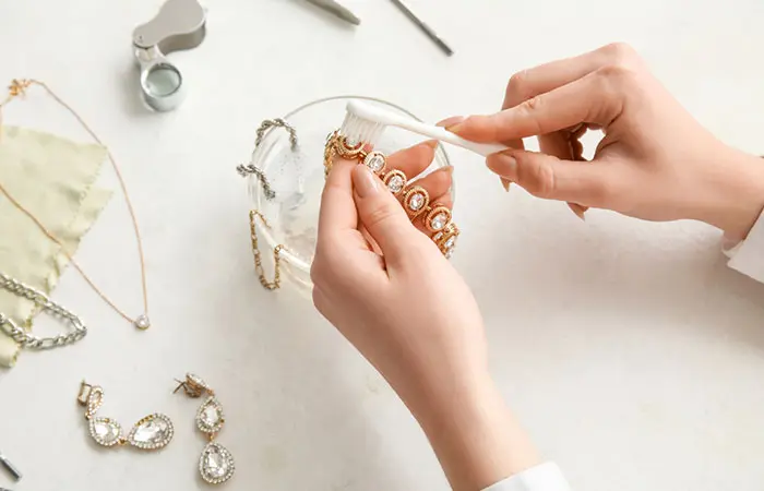 Close-up of hands of woman cleaning her jewelry