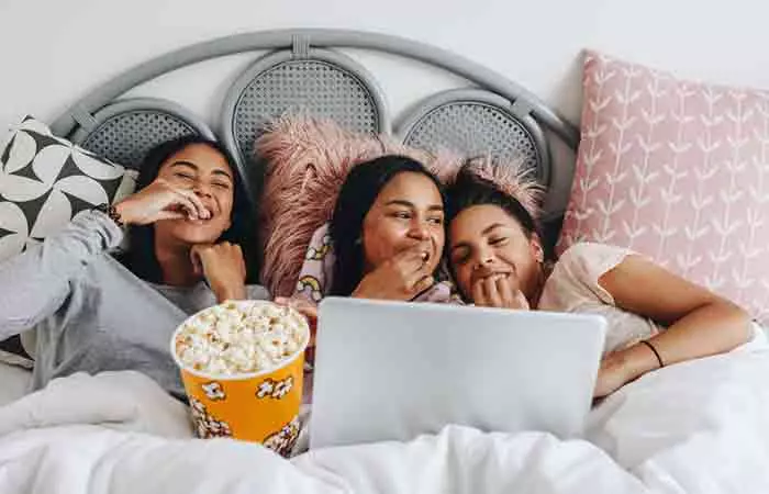 Girls watching a movie and having popcorn at a sleepover