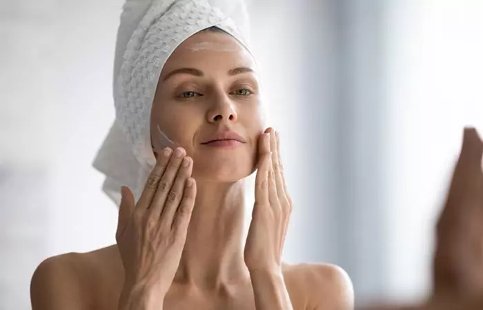 Woman massaging Selsun blue shampoo on her face