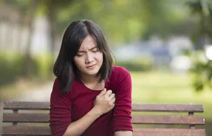 Woman experiencing chest pain due to excess use of blue lotus flower extract