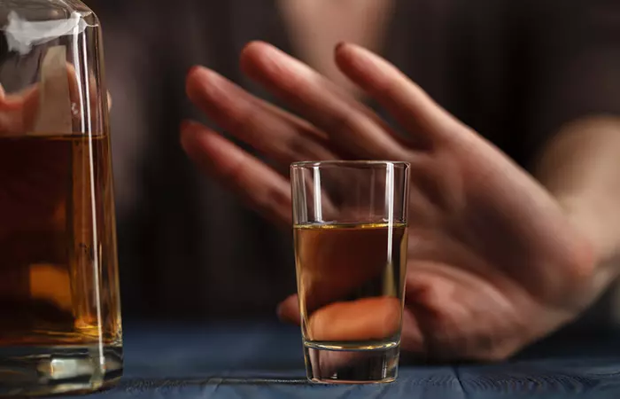 Close up of a pregnant woman's hand refusing tequila