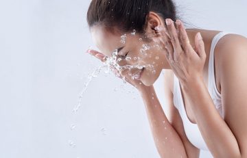 Woman washing face to prevent blackheads on cheeks