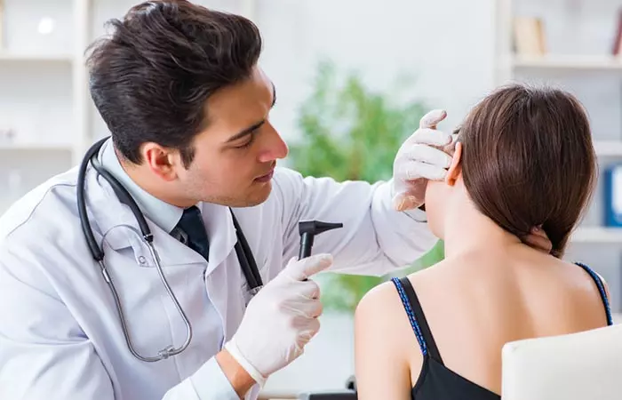 A doctor checks the ears of a patient