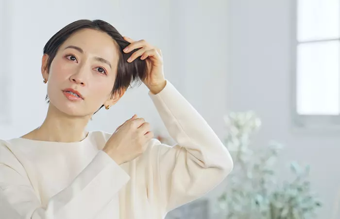 Woman checking out her hairline in the mirror