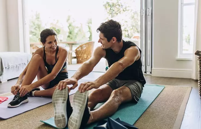 Adorable couple working out together in their home 