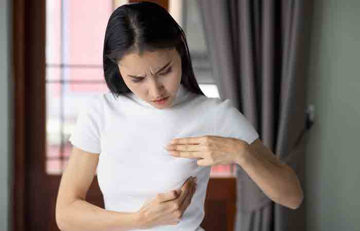 Woman inspecting her breast to check for cysts