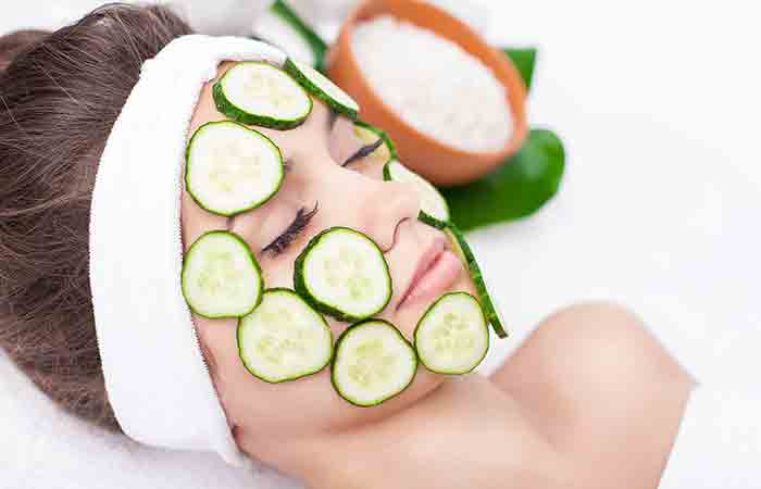 Woman with cucumber slices on sunburnt skin
