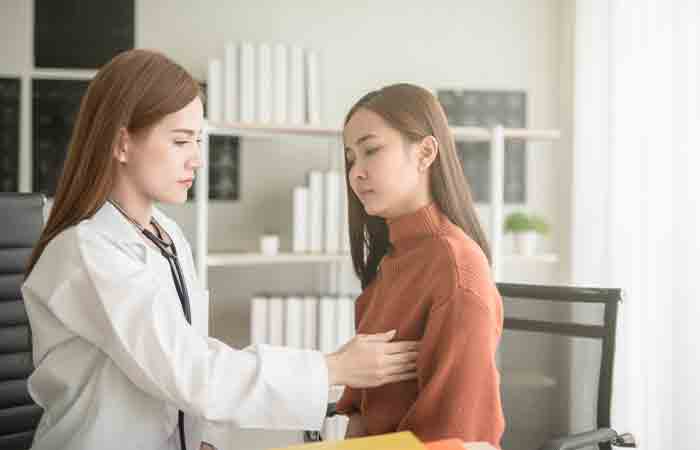 Doctor checking woman's breast for bumps