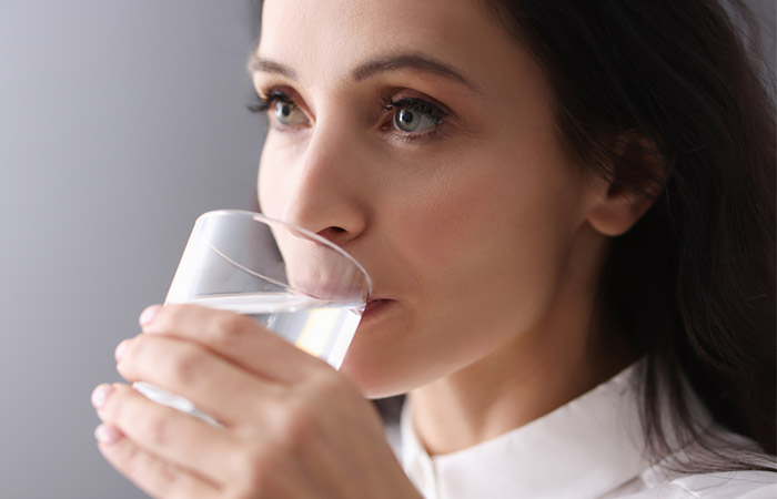 Woman drinking water to prevent dehydration and dry mouth